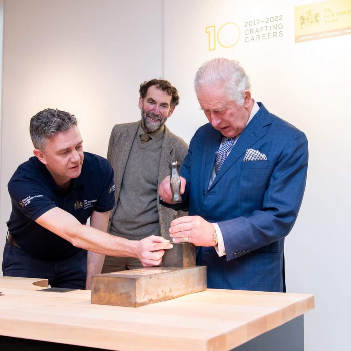 Liveryman Adam Phillips helps His Majesty hallmark a processional cross 