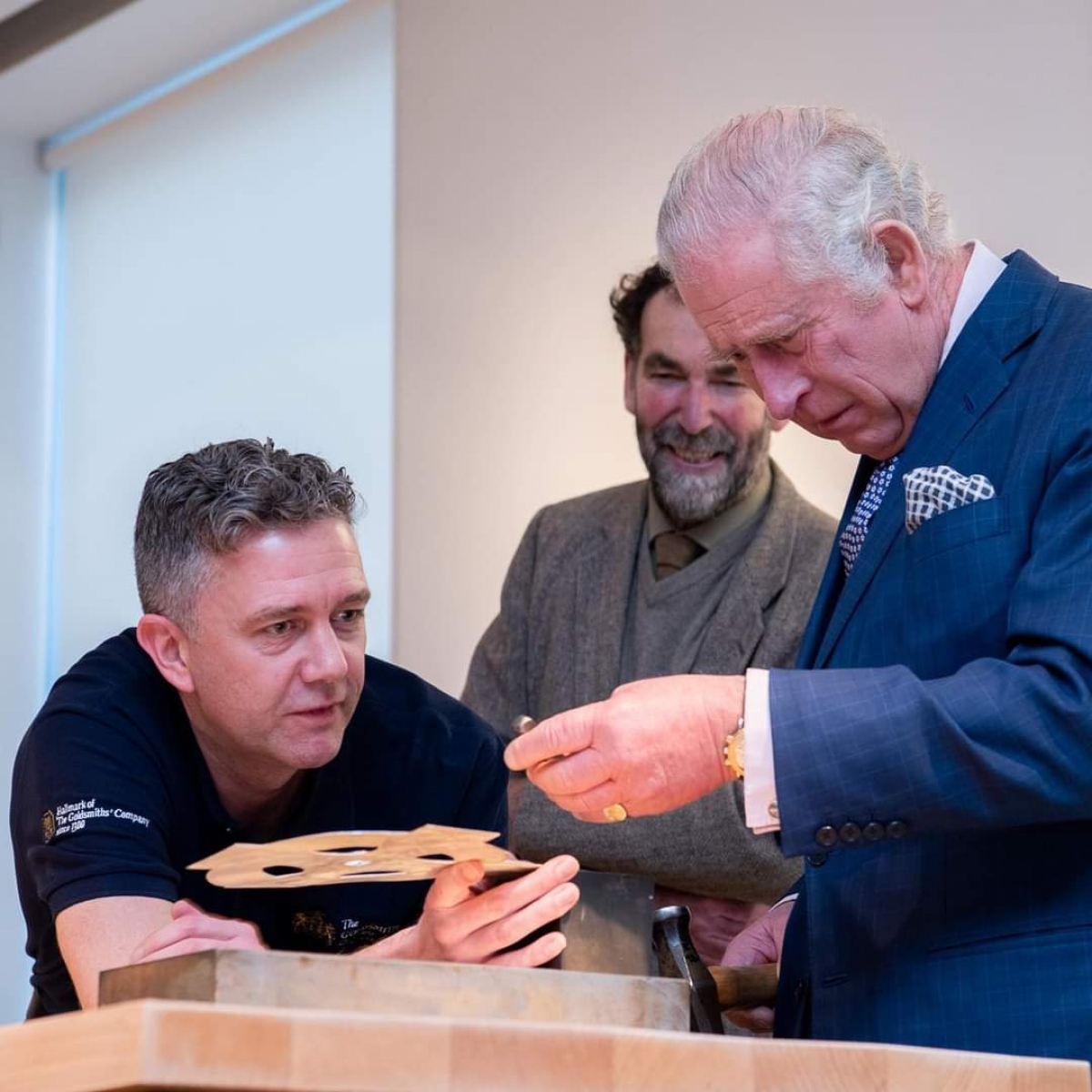 Liveryman Adam Phillips helps His Majesty hallmark a processional cross